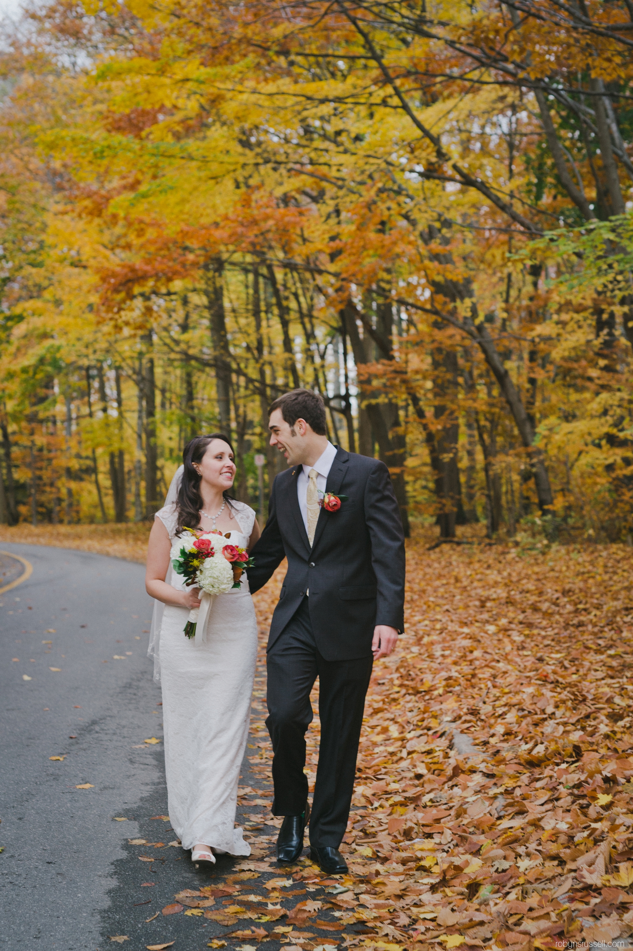 44-bride-and-groom-walking-fall-leaves-wedding.jpg