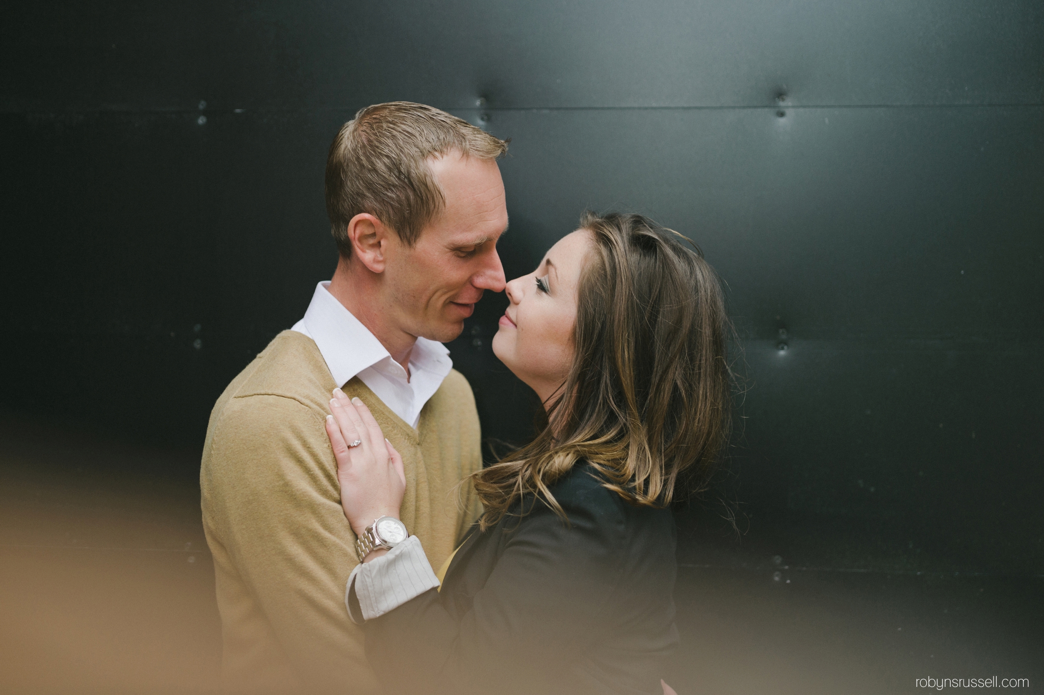 18-engaged-couple-sneaking-kiss-in-village-square-burlington.jpg