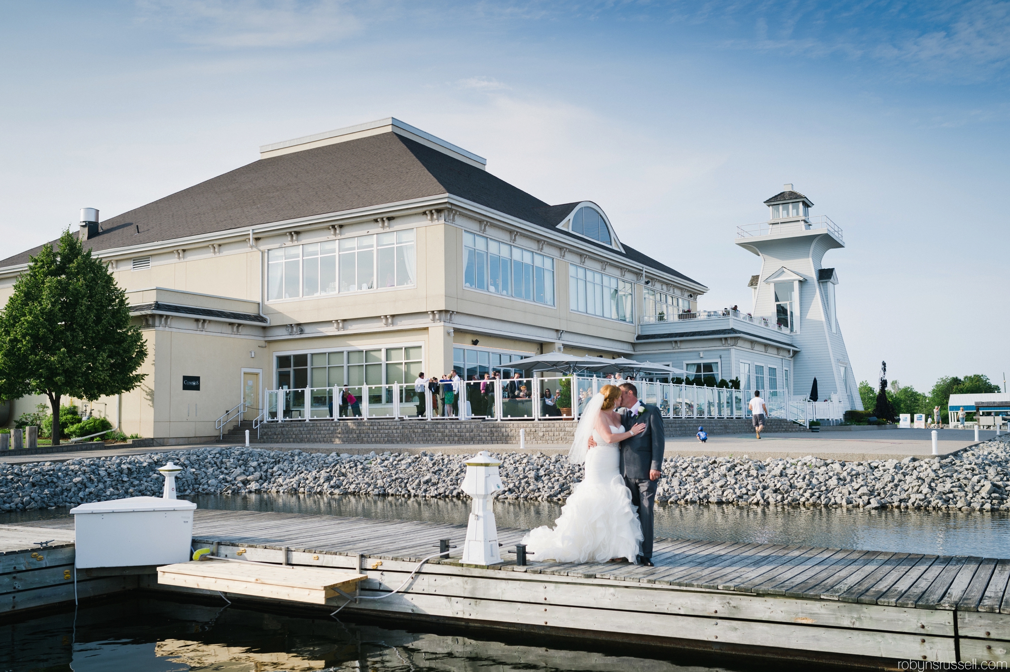 26-bride-and-groom-kiss-in-front-of-reception-area-oakville-harbour-banquet-center.jpg