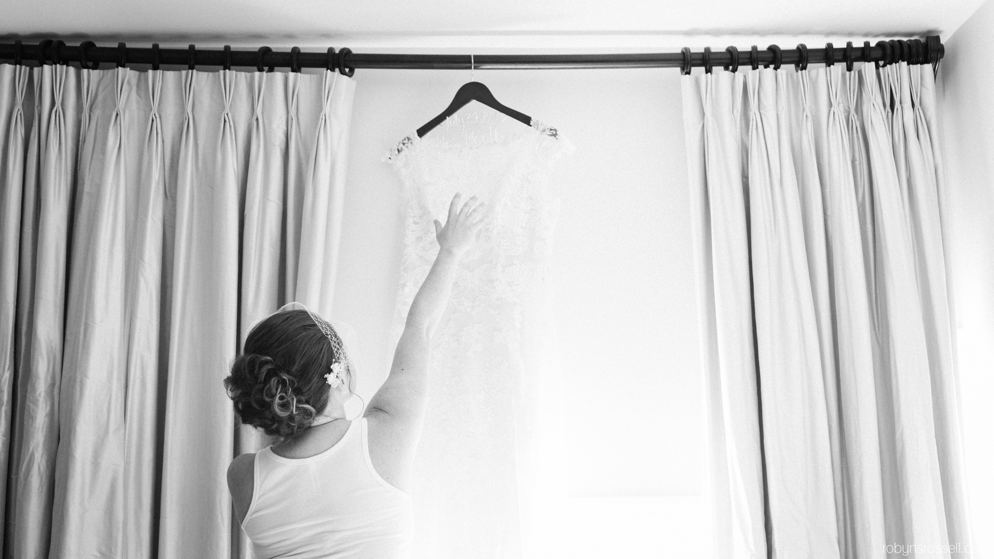 14-bride-reaching-for-wedding-dress.jpg